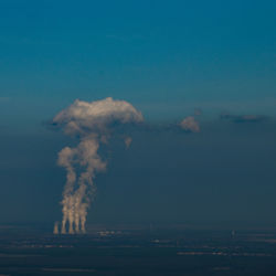 Smoke emitting from chimney against sky