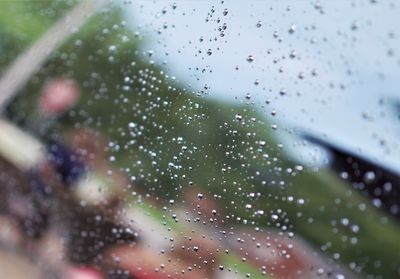 Close-up of wet glass window during rainy season
