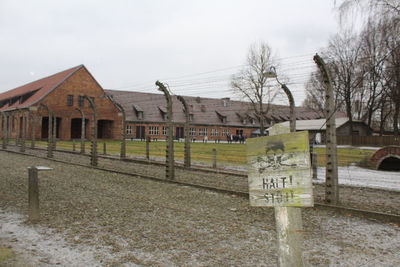 Information sign by building against sky