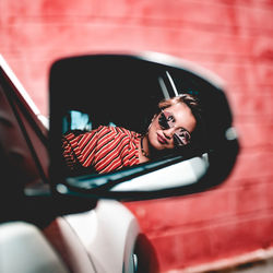 Portrait of a beautiful woman reflection thru the side mirror