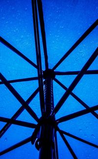 Low angle view of metallic structure against blue sky