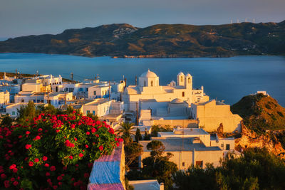 Scenic view of sea and buildings against mountain