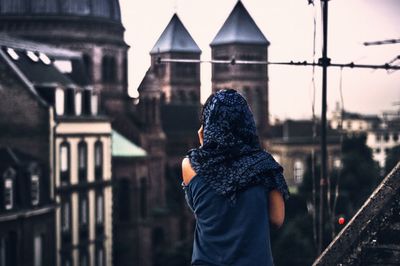 Rear view of woman looking at church in city