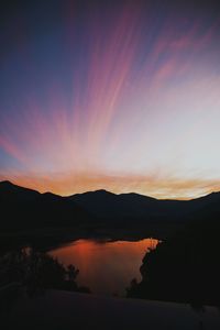 Scenic view of silhouette mountains against romantic sky at sunset