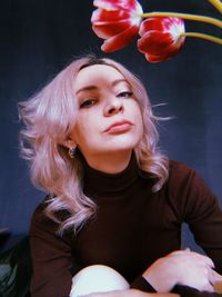 Portrait of beautiful woman with red flower