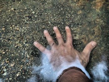High angle view of person hand on wet floor