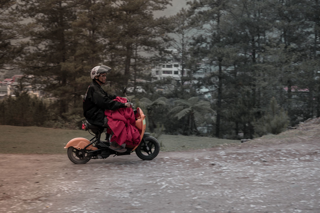 FULL LENGTH OF MAN RIDING BICYCLE ON ROAD