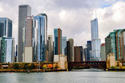 Low angle view of skyscrapers against cloudy sky