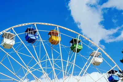 Ferris wheel with multi-colored cabins against the blue sky