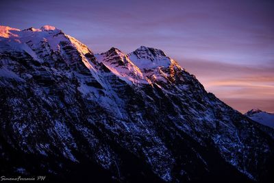 Scenic view of snowcapped mountains against sky during sunset