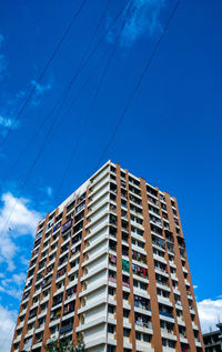 Low angle view of modern building against blue sky