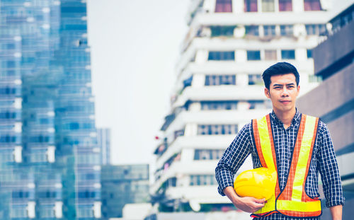 Portrait of young man standing in city