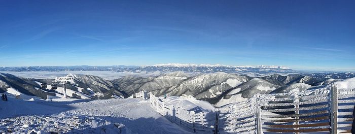 Scenic view of snowcapped mountains against blue sky