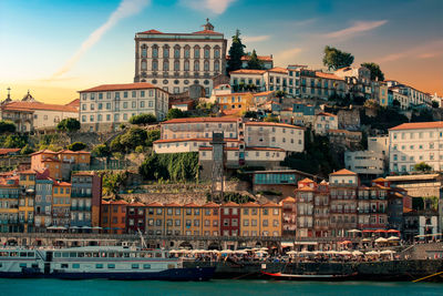 View of buildings at waterfront against cloudy sky