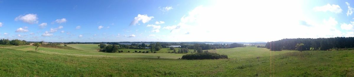 Scenic view of grassy field against cloudy sky