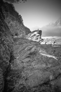 Rock formations on shore against sky