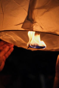 Close-up of hand holding lit candle