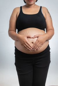 Low section of woman standing against white background