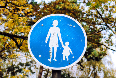 Low angle view of road sign against blue sky