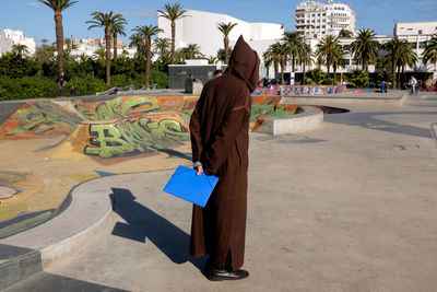 Rear view of man walking in swimming pool