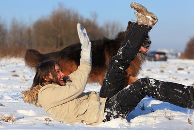 Woman with dog on snow covered land