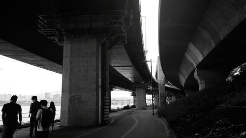 People walking under bridge