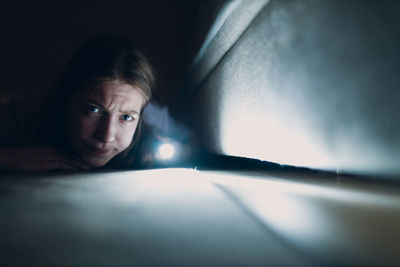 Portrait of young woman looking through window