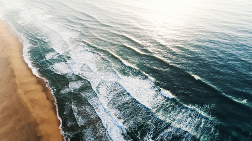 Aerial view of waves rushing towards shore