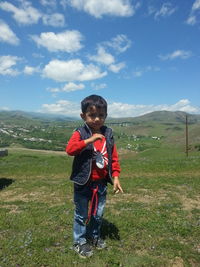 Portrait of boy standing on mountain against sky