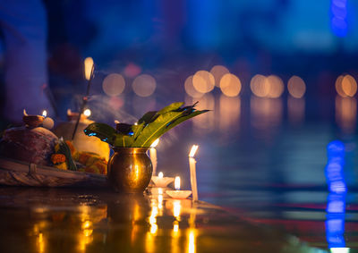 Close-up of illuminated candles on glass table