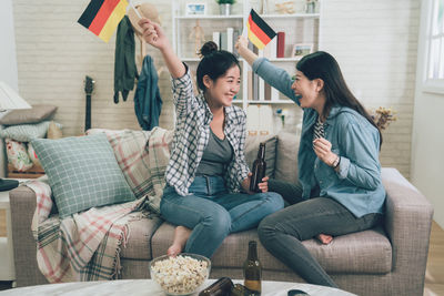Young women sitting on sofa at home