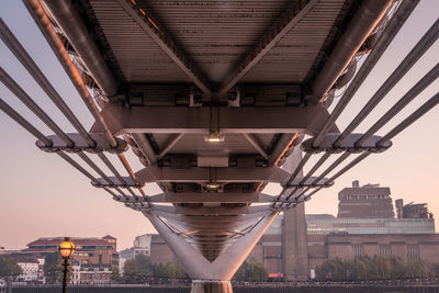 Underneath of bridge against buildings and sky