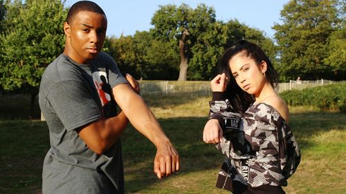 Portrait of friends standing on field at park