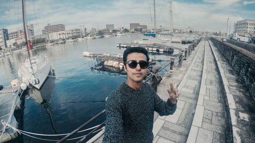 Portrait of young man standing on pier