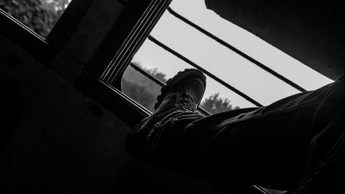Low section of person relaxing on window