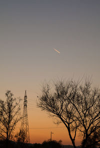 Low angle view of silhouette trees against clear sky during sunset