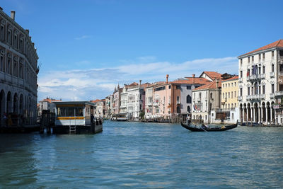 Boats in canal amidst buildings in city