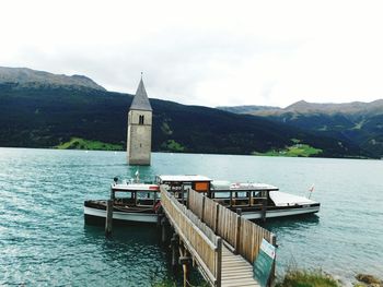 View of jetty in calm sea against mountain range