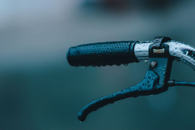 Close-up of wet bicycle handlebar during rainy season