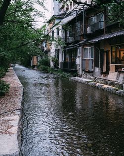 Canal amidst buildings during rainy season