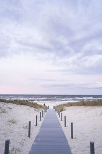 Wooden pier on sea against sky