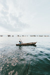 Man in sea against sky