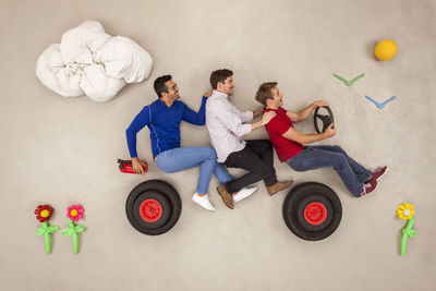 High angle view of people with toy against gray background