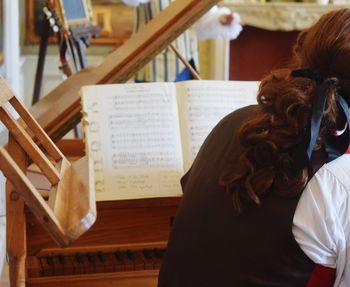 Rear view of woman playing piano