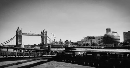 Bridge over river in city against sky