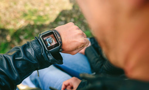 Close-up of hand holding clock against blurred background