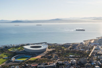 High angle view of city by sea against sky