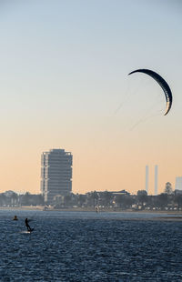Scenic view of sea and buildings against sky during sunset