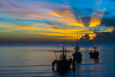 Silhouette sailboats in sea against sky during sunset