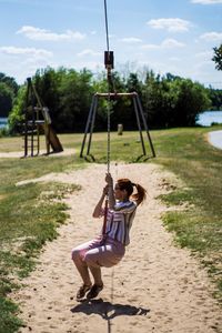Full length of girl on swing in playground